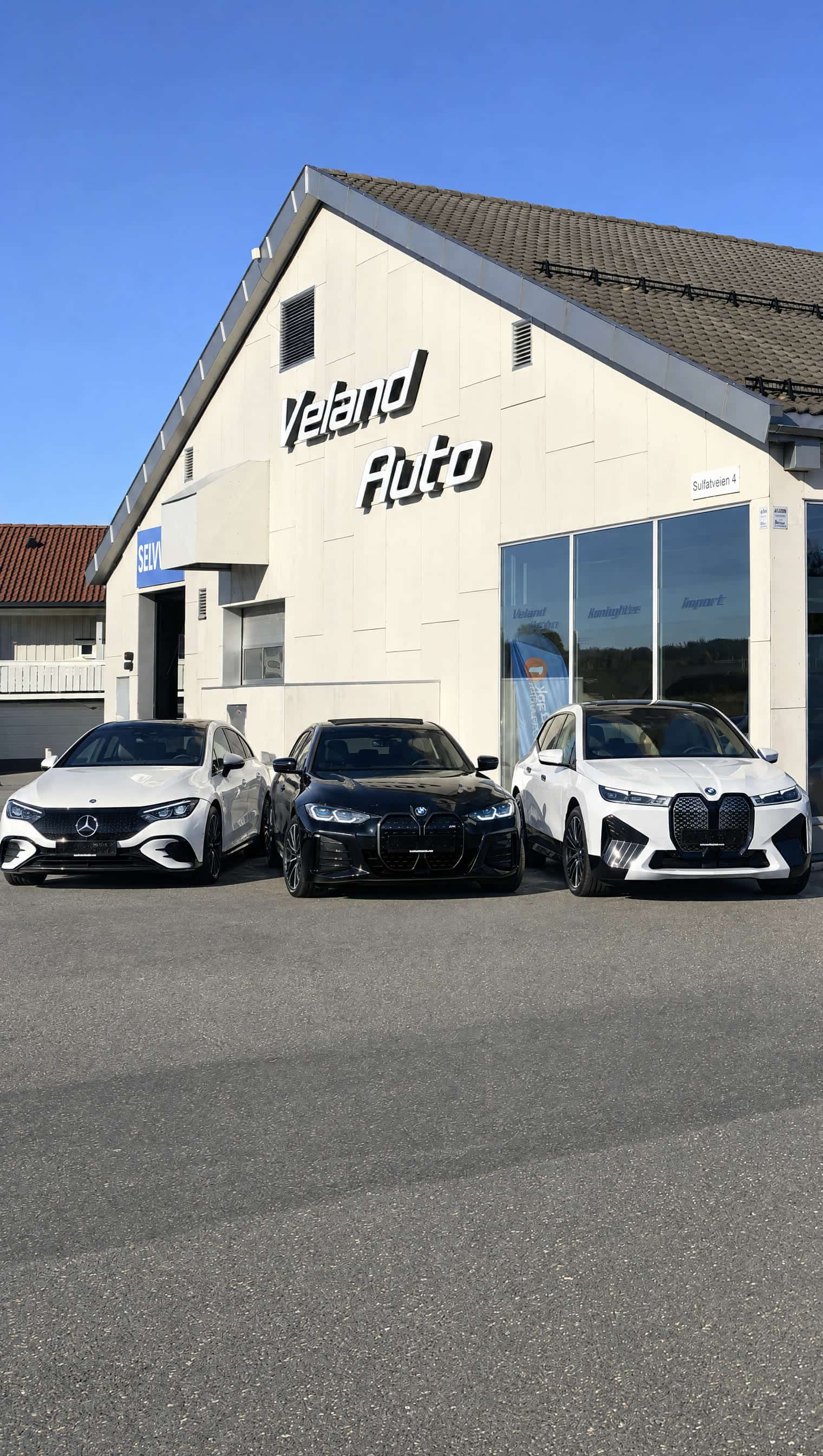 The Veland Auto showroom at Sulfatveien 2 in Torp with cars lined up in front